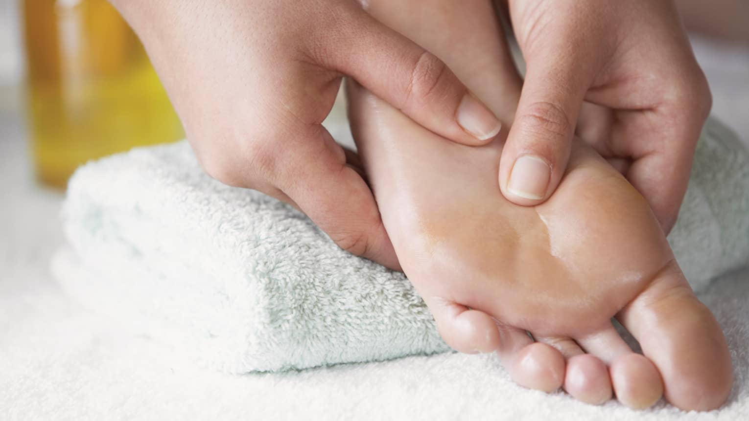 Close-up of hands massaging pressure points on feet