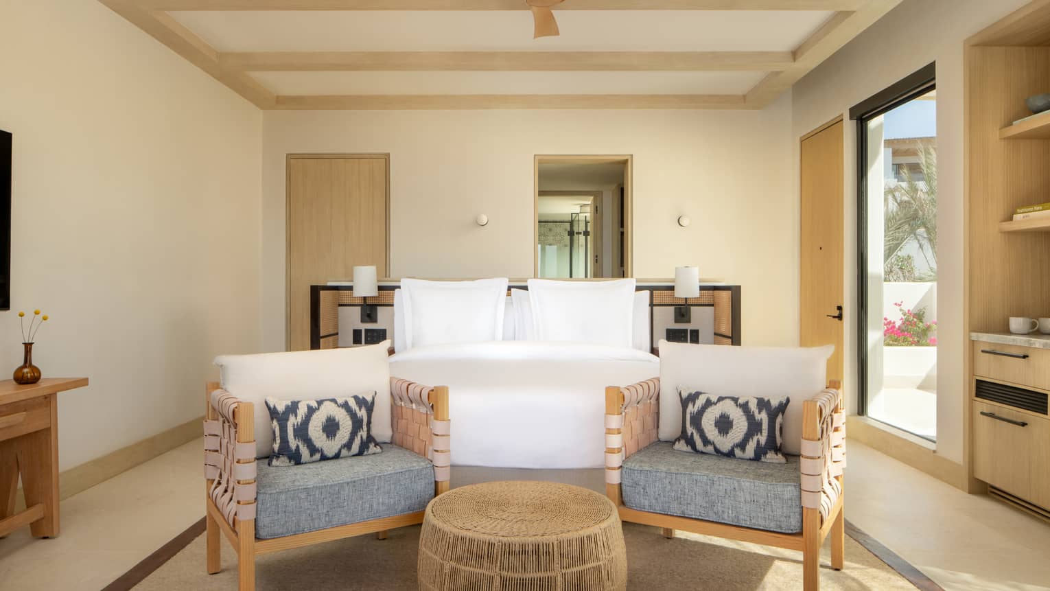 Luxury villa bedroom with king bed and two chairs, with door leading to outdoor terrace, at Four Seasons Resort Cabo San Lucas at Cabo Del Sol