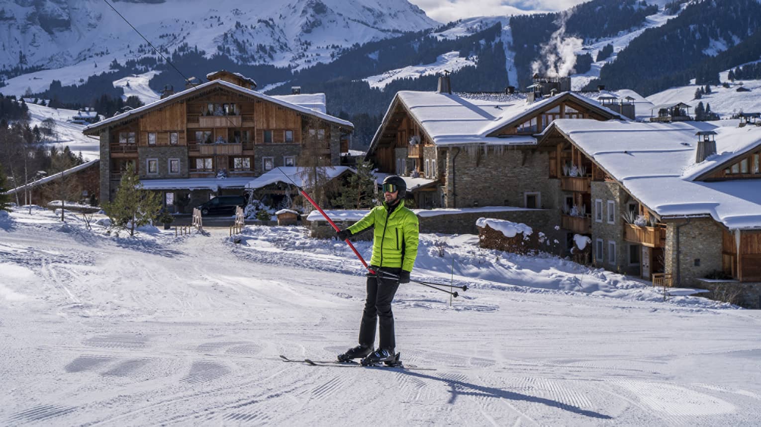 A person in a bright green ski jacket on snow.