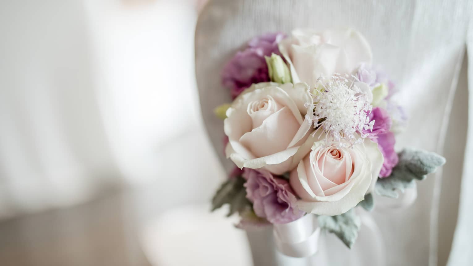 Close-up of white and purple rose flower corsage