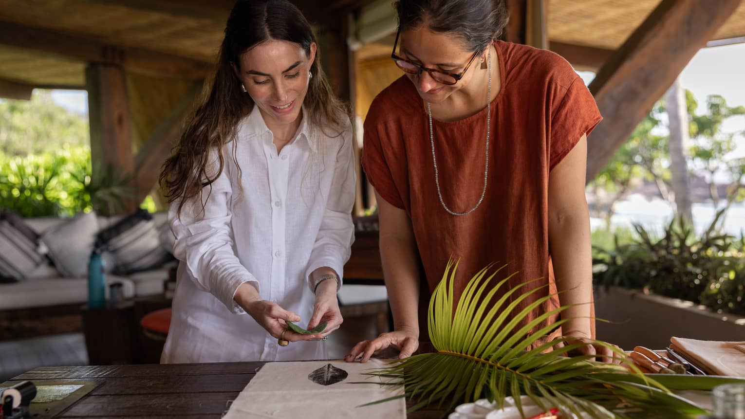Two women work on artwork at open-air restaurant