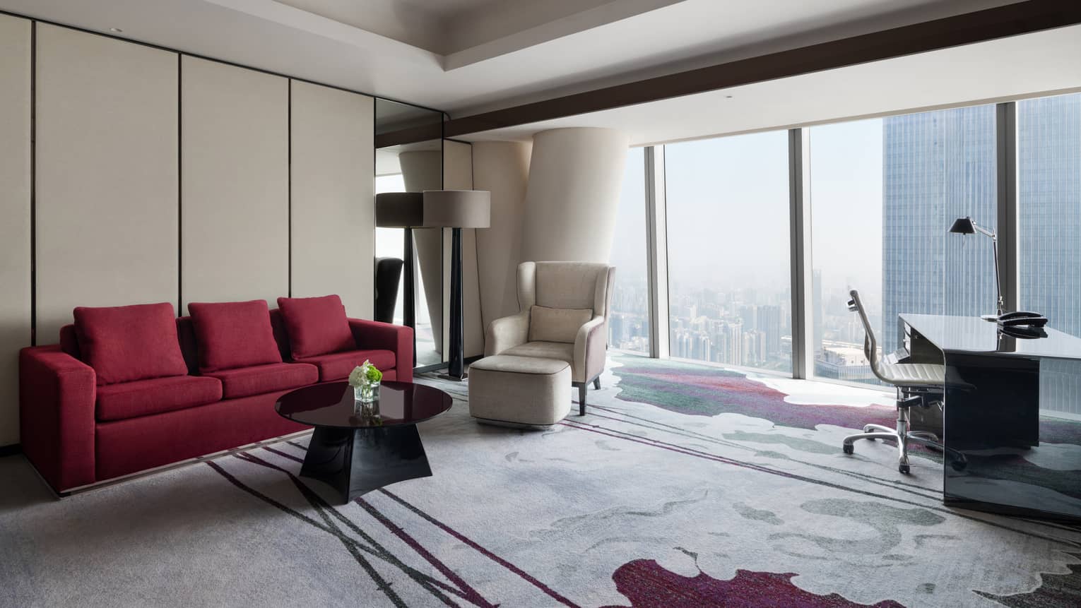 Deluxe King River View Suite living area with red sofa and floor-to-ceiling windows
