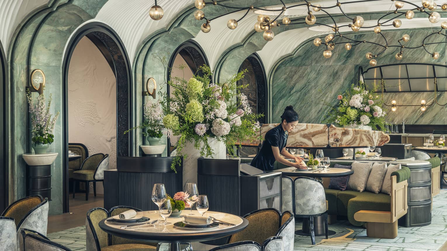 Woman sets table at contemporary Chinese restaurant Song at Four Seasons Hotel Hangzhou at Hangzhou Centre