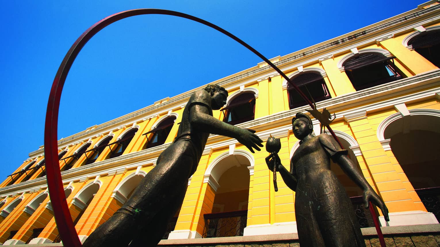 Friendship statue of girl handing a lotus flower to man outside Macau Museum of Art