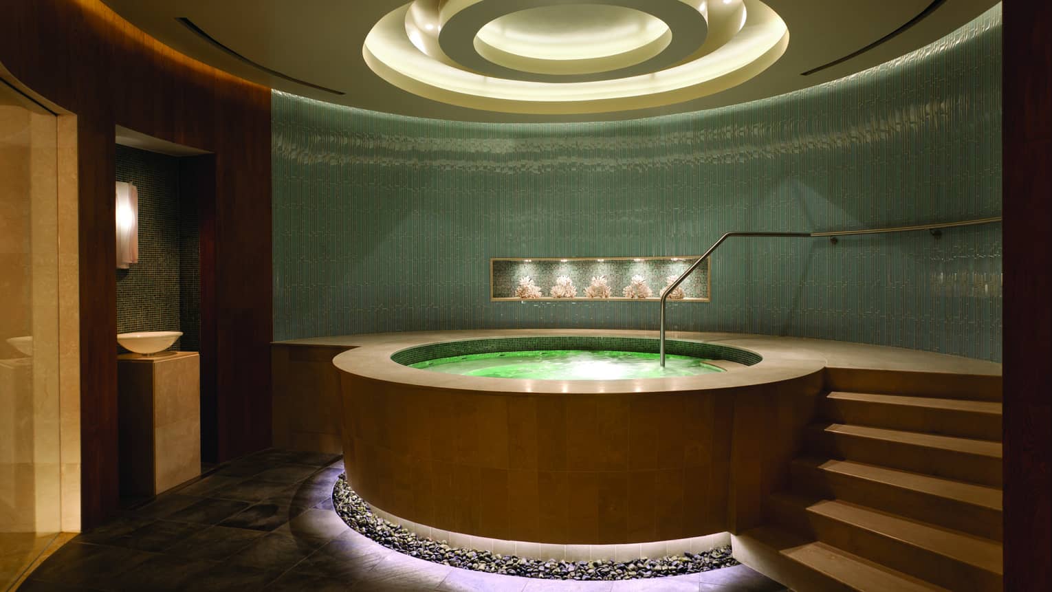 Round illuminated spa whirlpool in room with steps, recessed dome ceiling with lights 