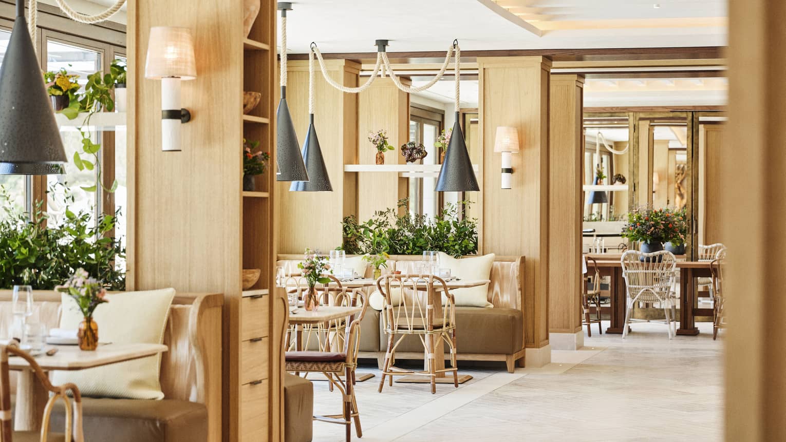 Light-filled restaurant Mel at Four Seasons Resort Mallorca, featuring natural furnishings and hanging metal lights