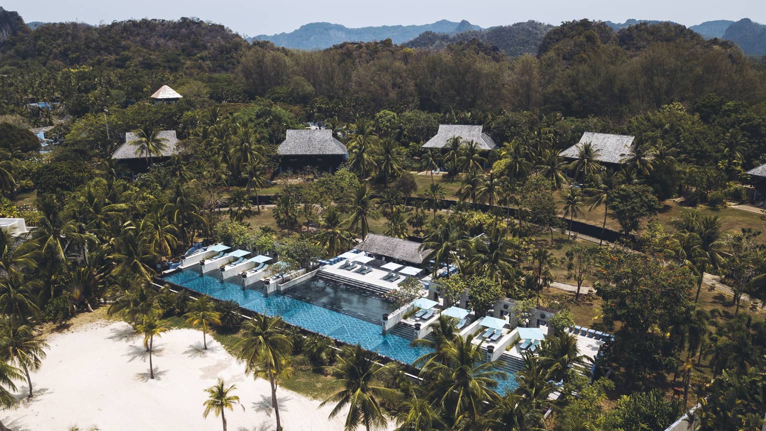 Aerial view of Resort, showcasing the pool and Malaysian forests of palm trees beyond