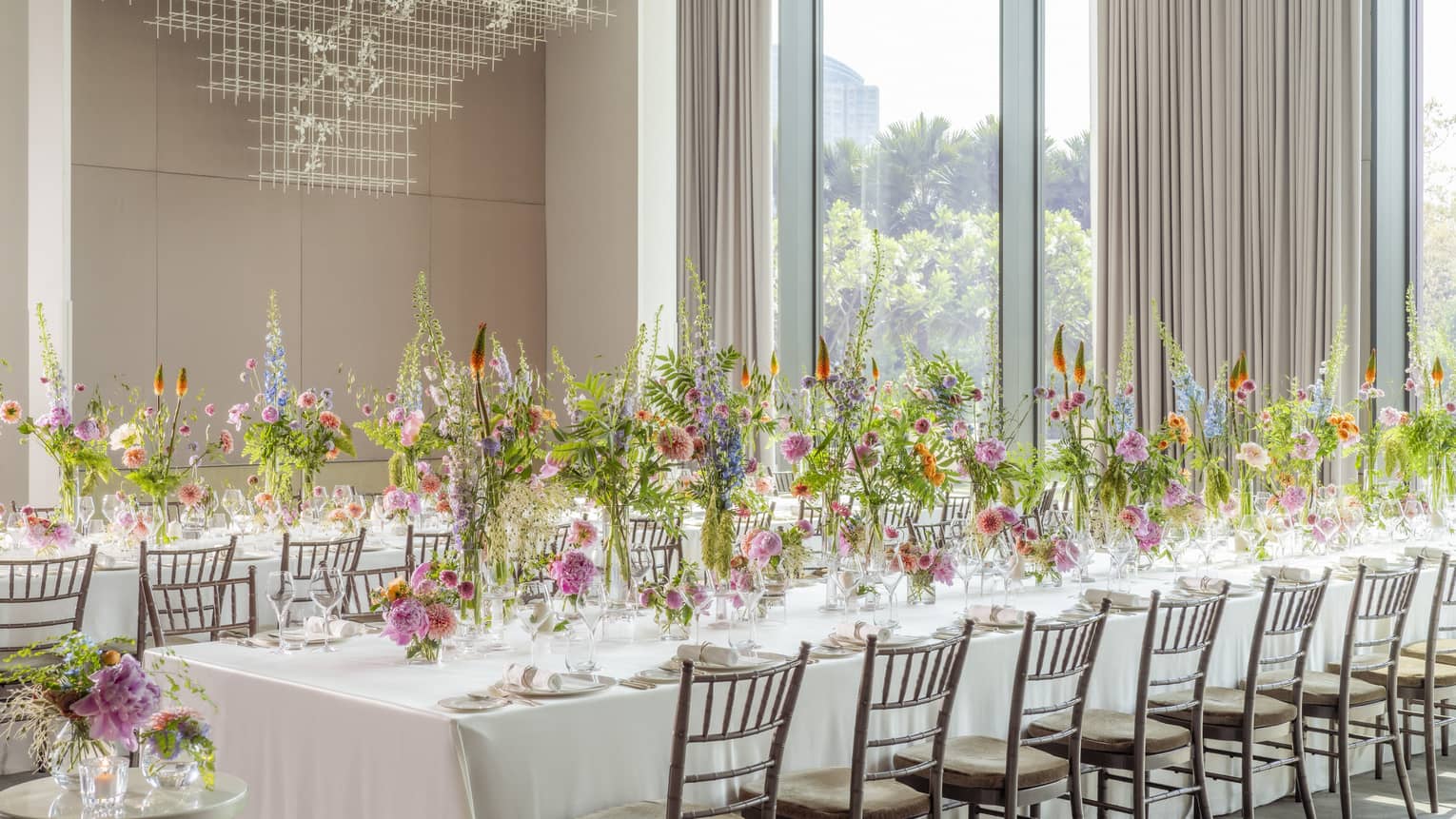 Ballroom set classroom-style with white linen?covered tables and tall floral centrepieces