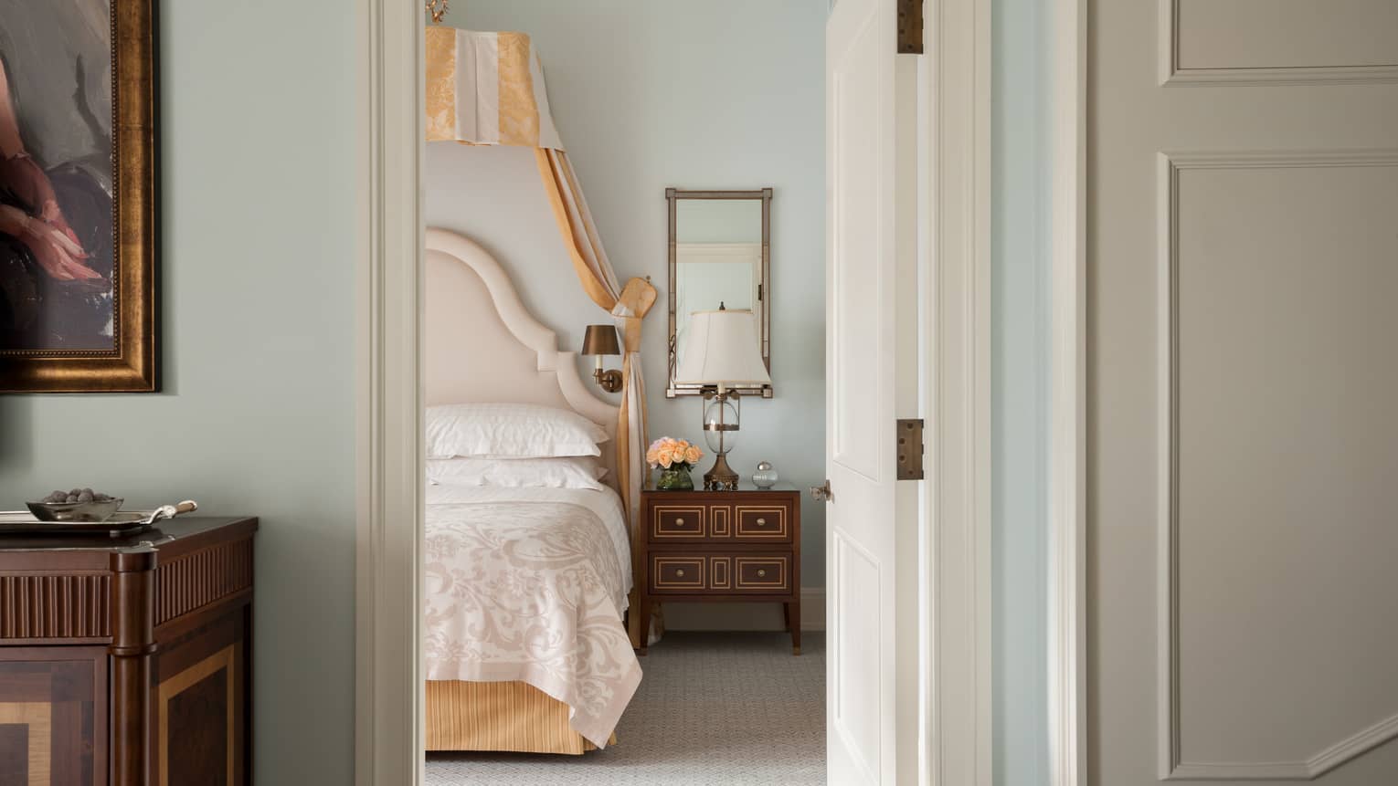View of edge of bed with intricate headboard through doorway in Terrace Room