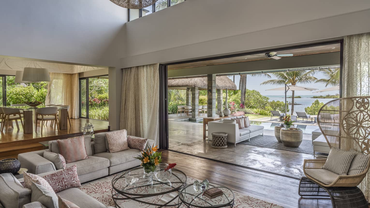 Large living room with high ceilings, two sofas, large opening to outdoor terrace