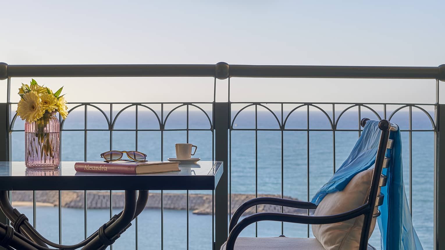 Balcony with small square table and chair, sea views