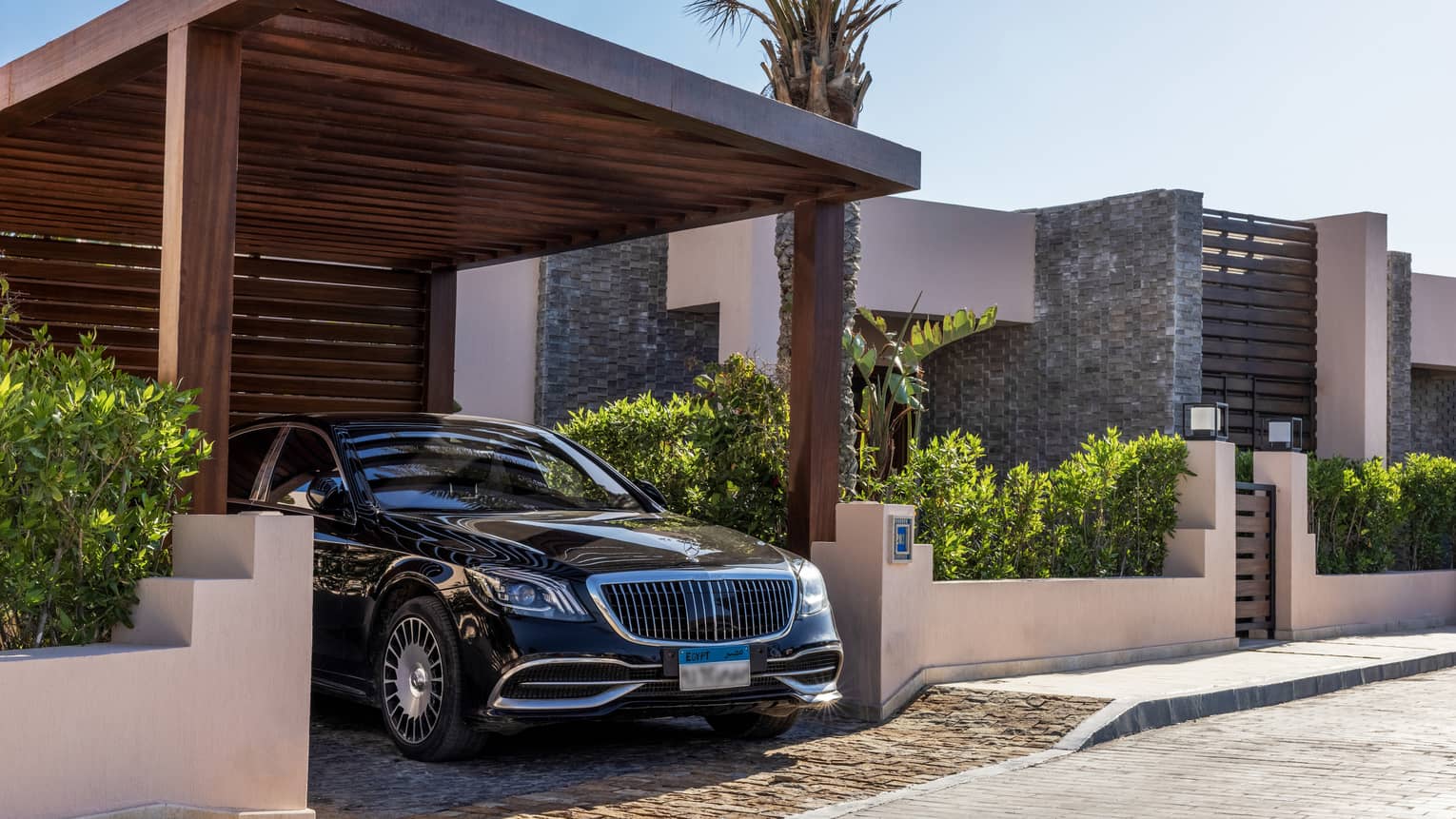 Sleek black hotel car under portico of the One-Bedroom Beach Villa