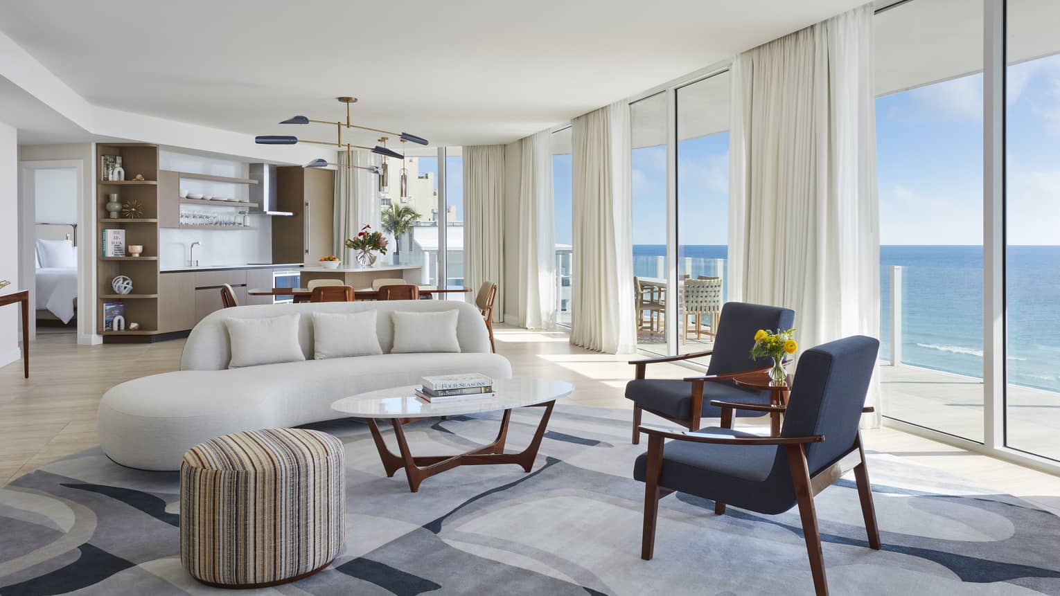 Living room and dining room with wall of windows, ocean view