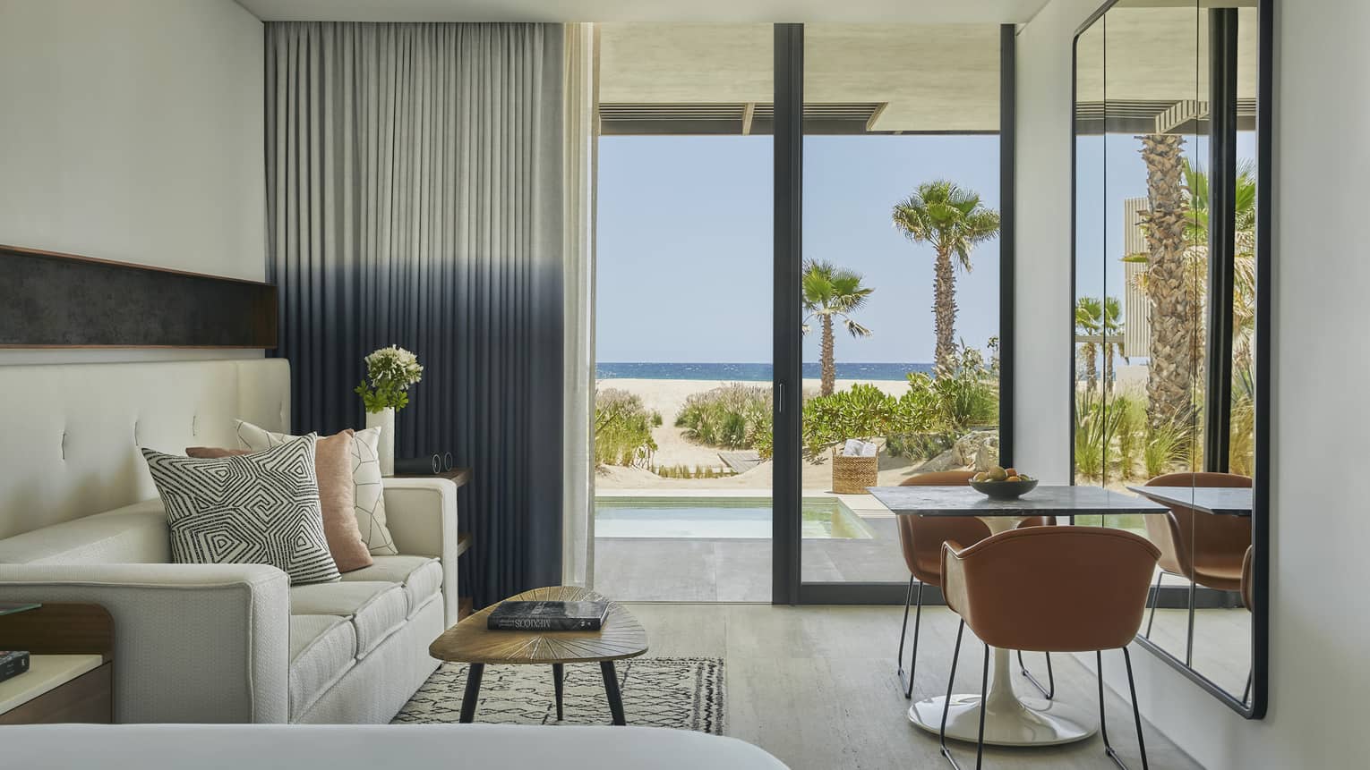 A living room suite with a couch, small table, two chairs, and large window.