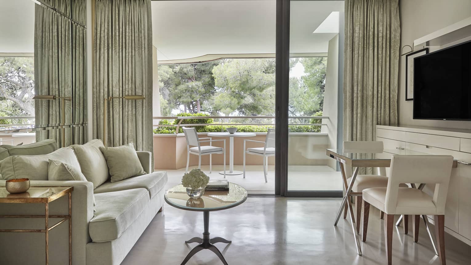 Neutral living room with coffee table, bistro set under TV, large patio doors, patio view