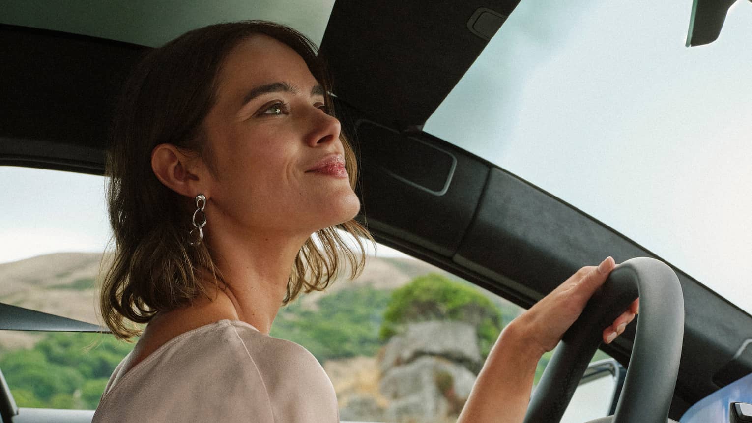 A guest looking out of the front window while driving a car