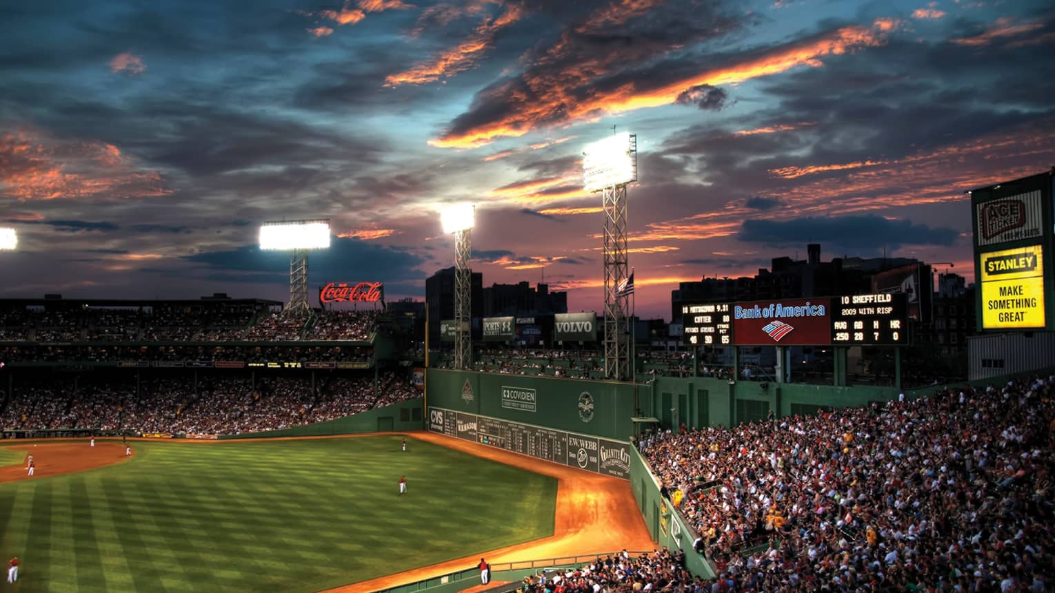 the sun sets over fenway park in boston