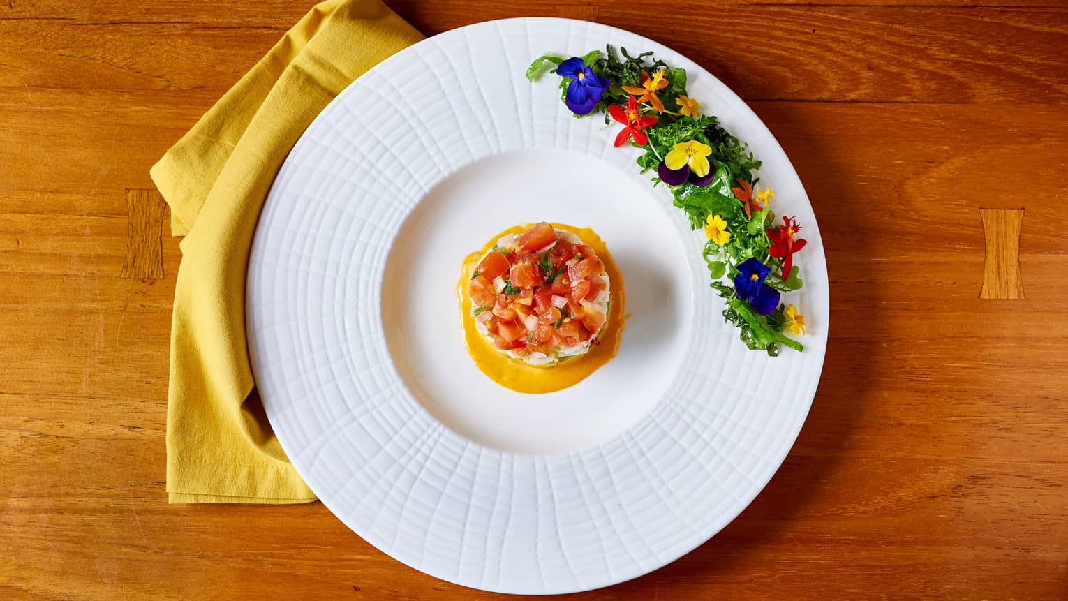 Aerial view of Lobster Tower cold seafood dish lined with edible flowers