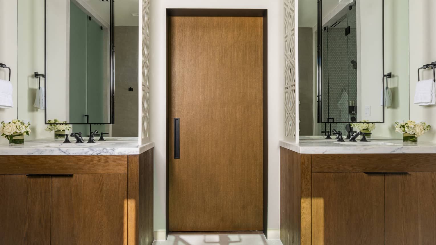 Bathroom with a wood-and-marble vanity on either side of the door