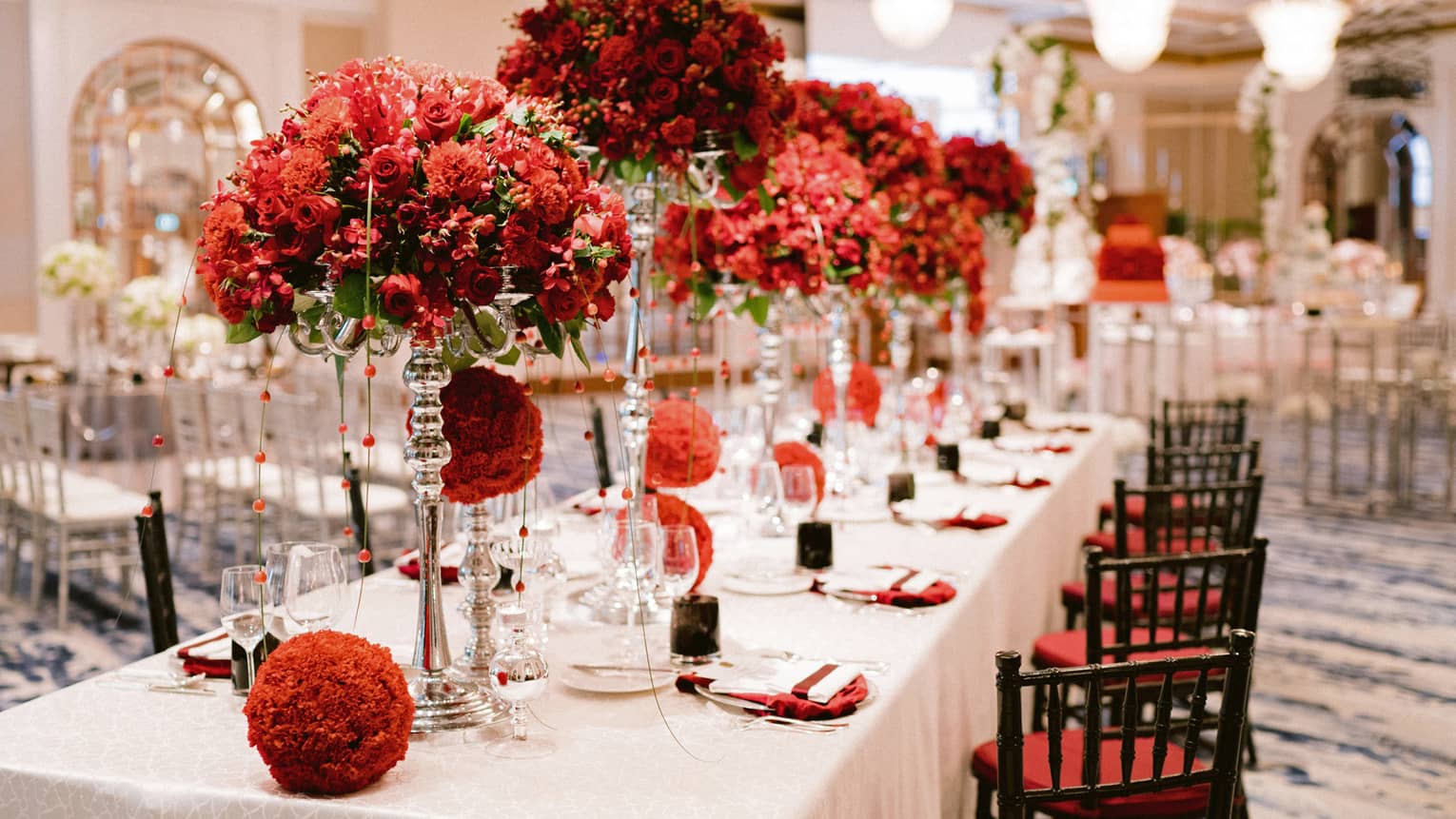 Red flower arrangements on dining table in wedding reception banquet room