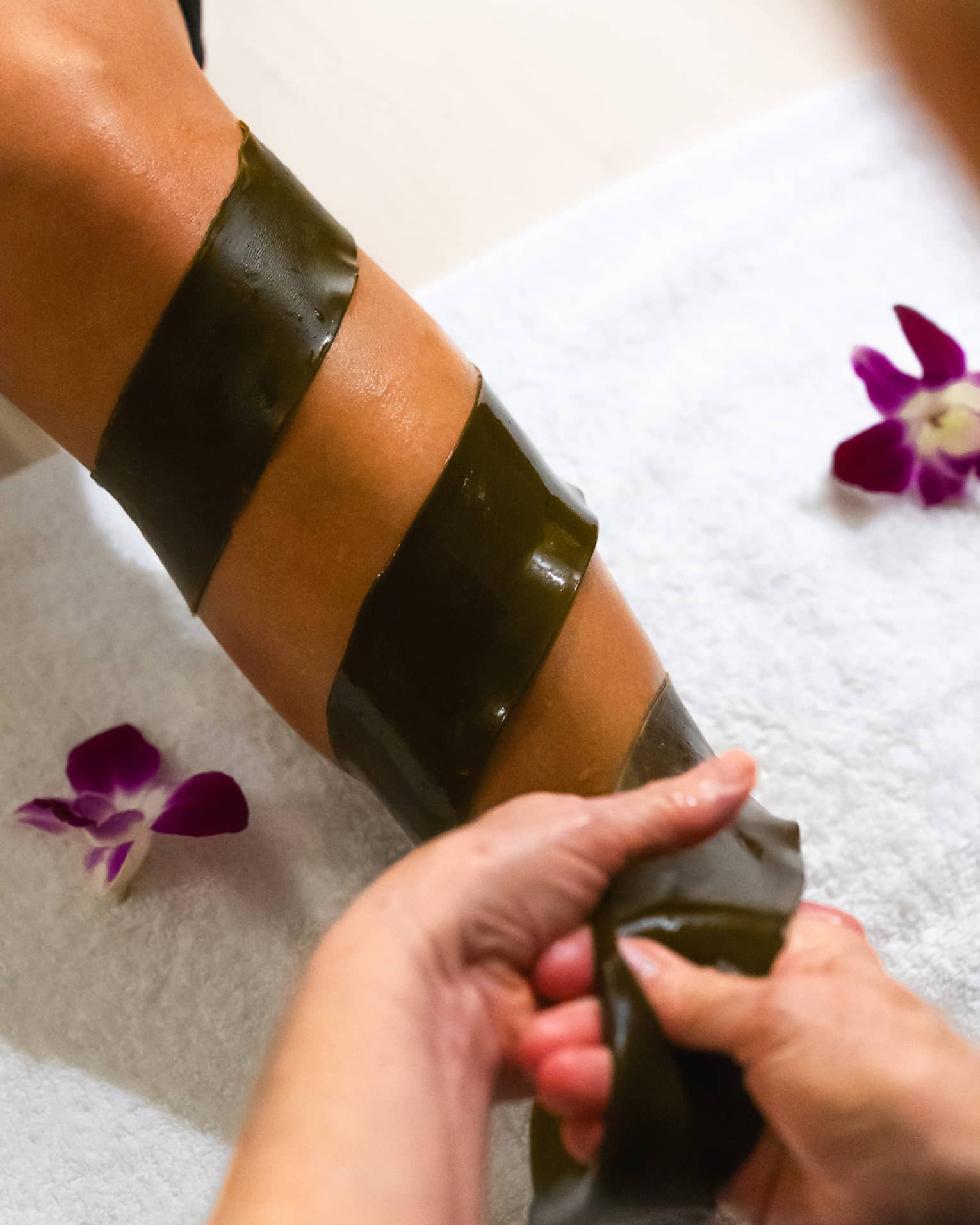 A piece of seaweed is being wrapped around someone's arm
