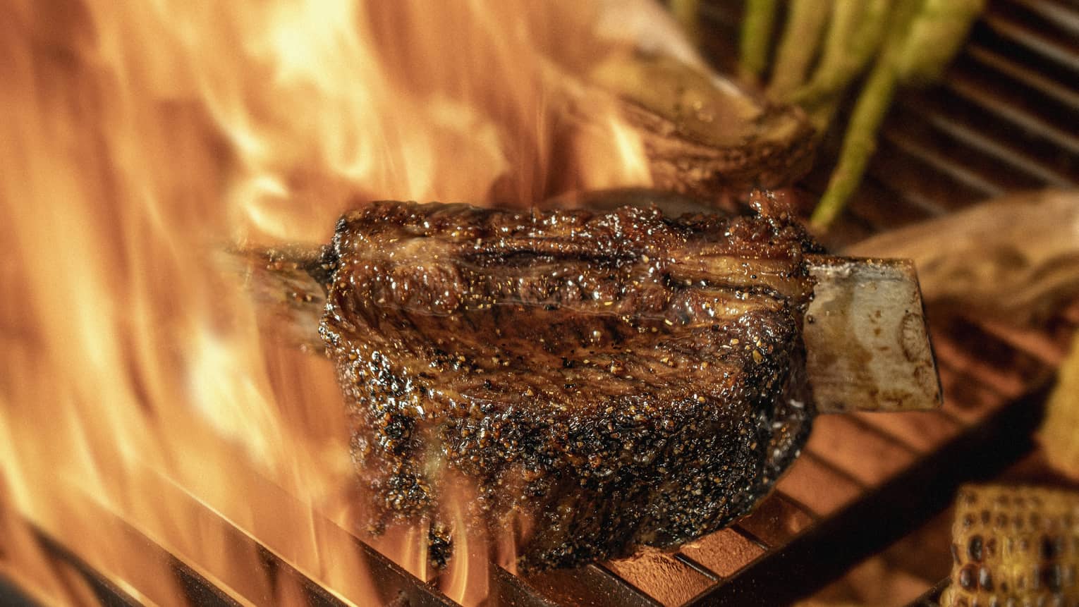 Close-up of chargrilled steak, asparagus and corn on grill grates