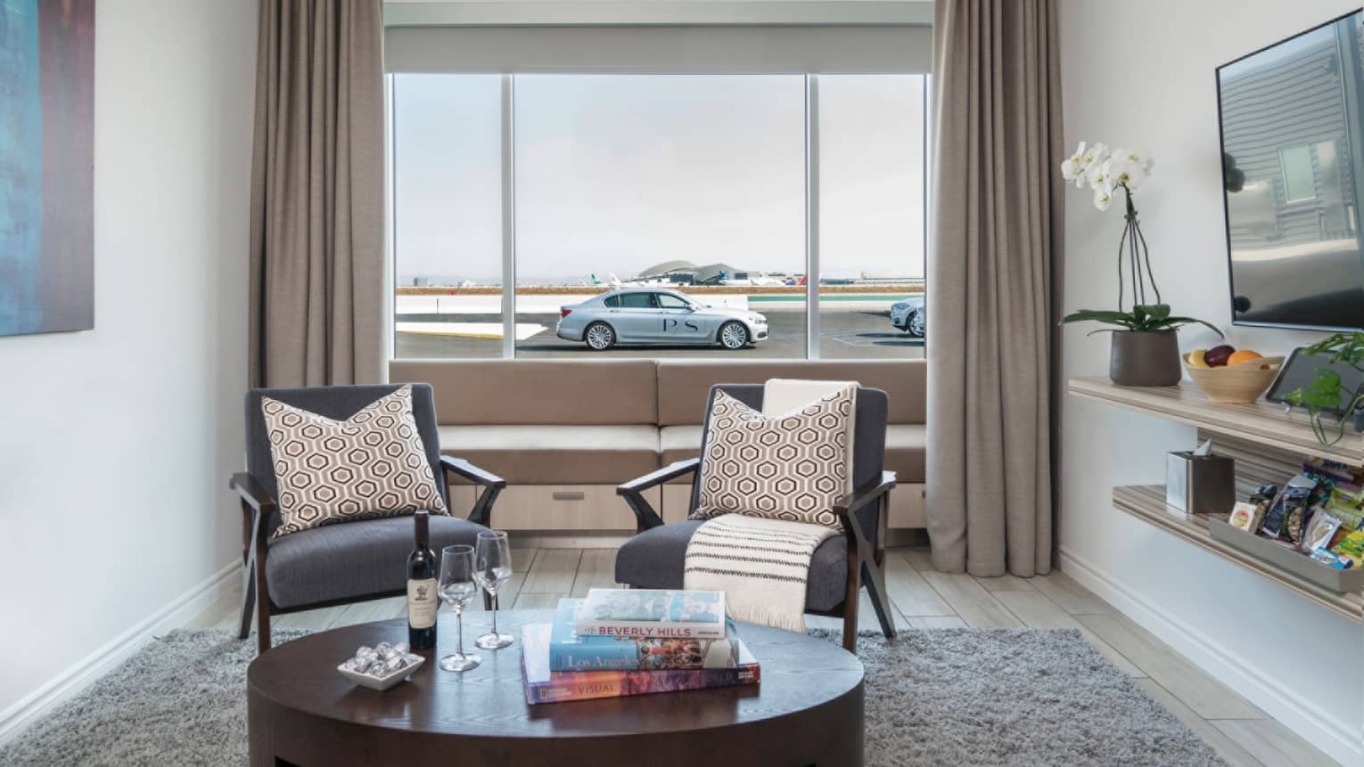 Private airport Suite seating area, car and runway in background through window