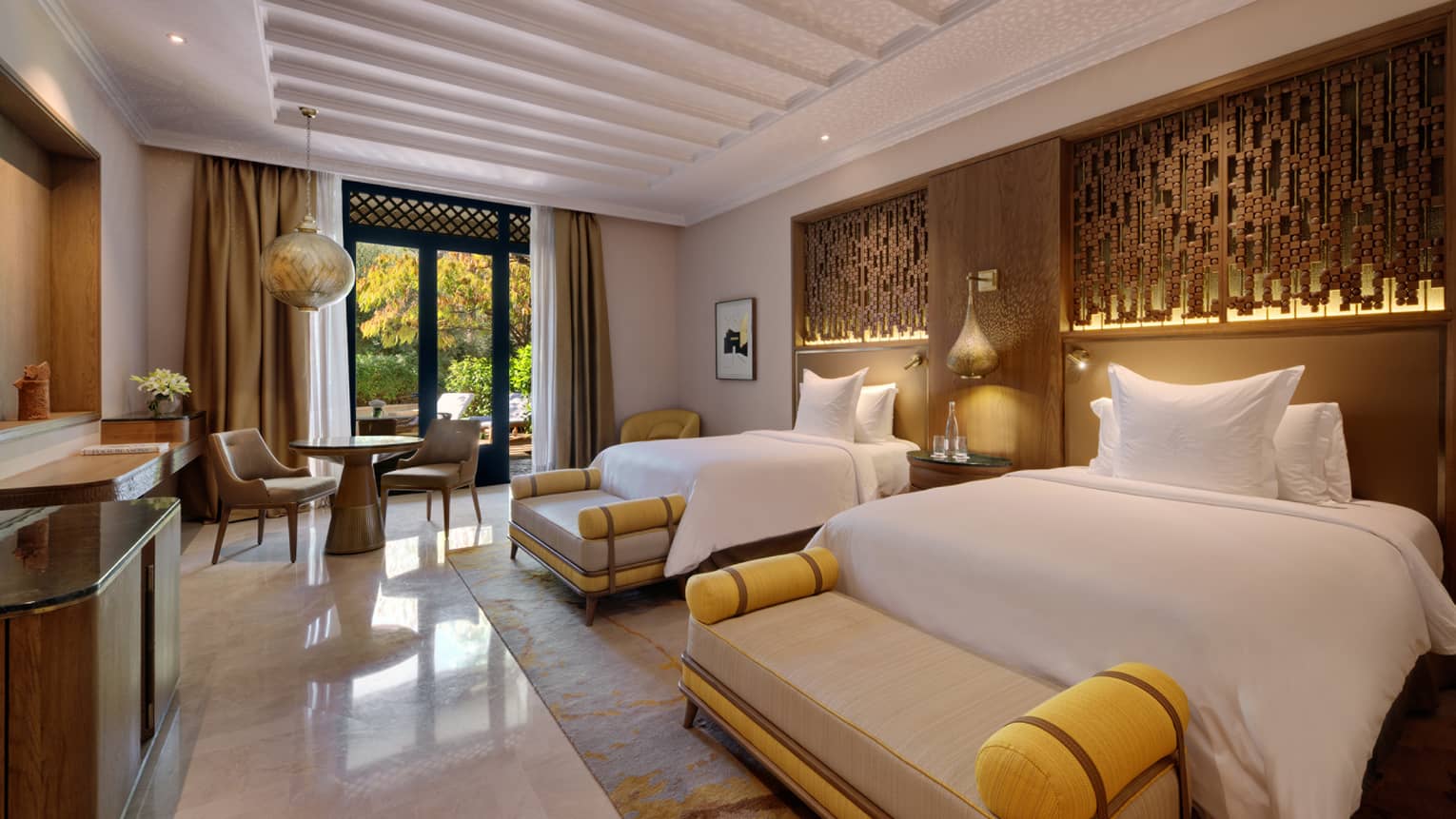 Hotel room with two beds, a cushioned bench at the end of each bed