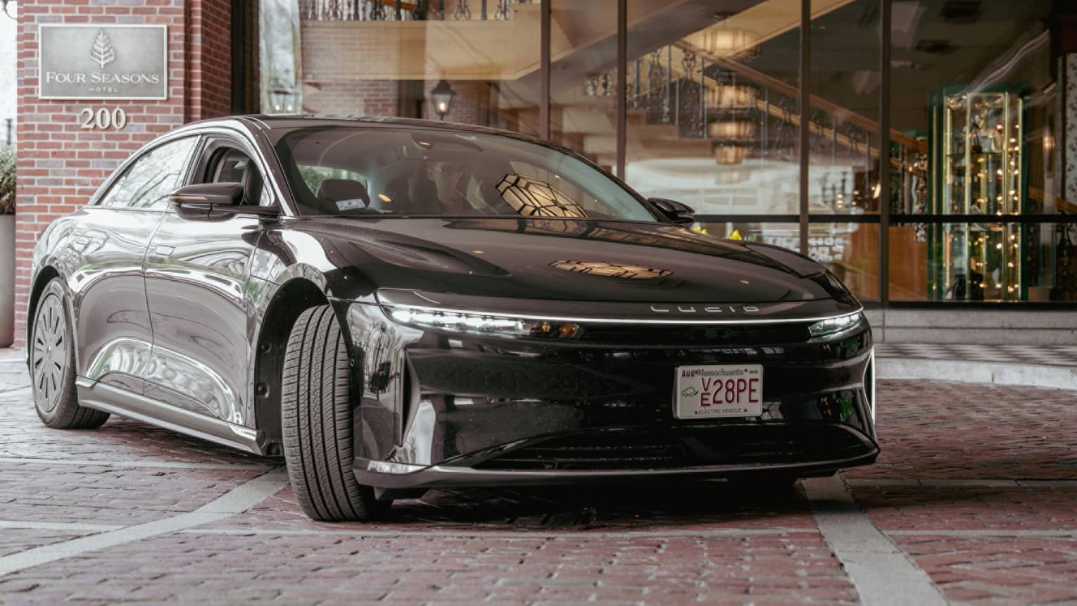 Black Lucid car parked outside a hotel on a brick road