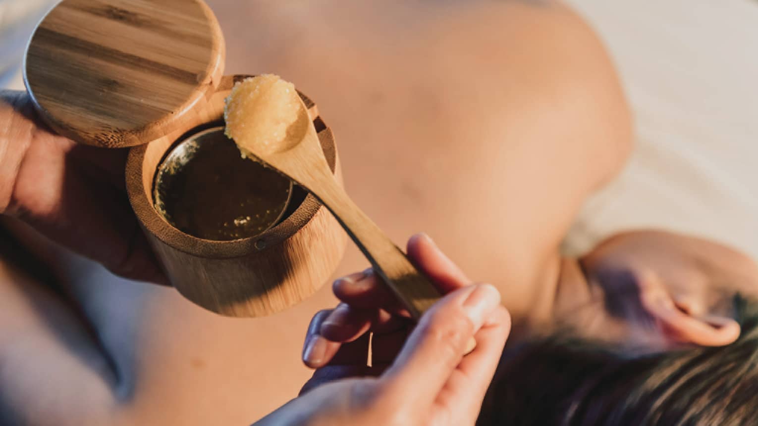 A spa scrub is placed on a guest's back during a relaxing treatment