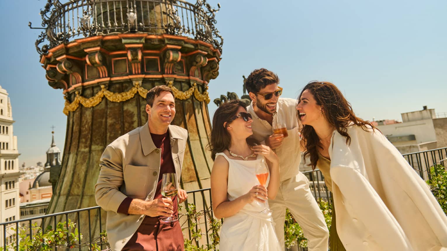 Four guests standing outside, smiling and laughing together