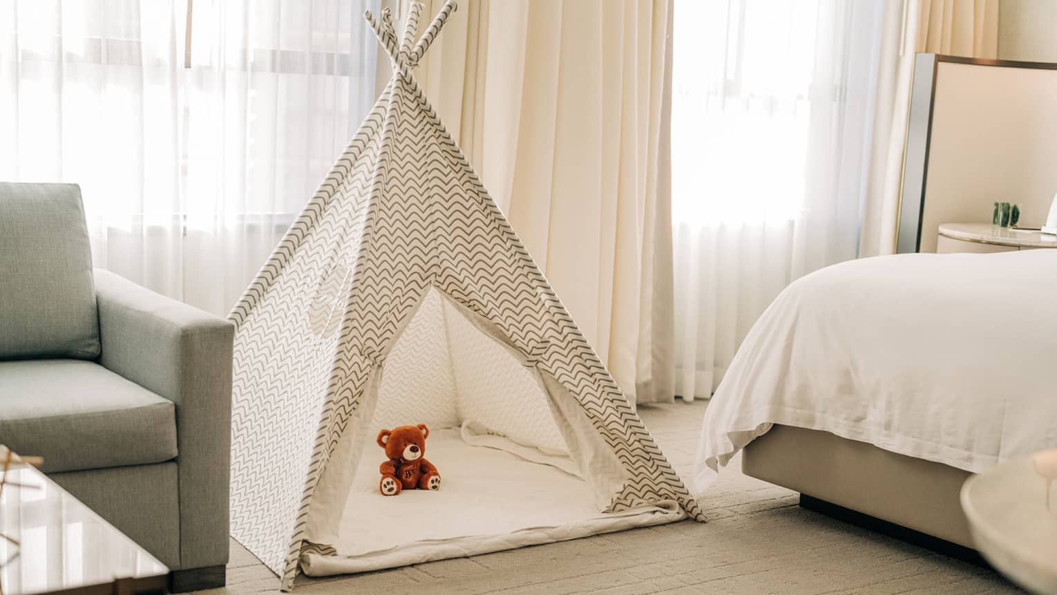 A kids tent with a stuffed animal in a guest room