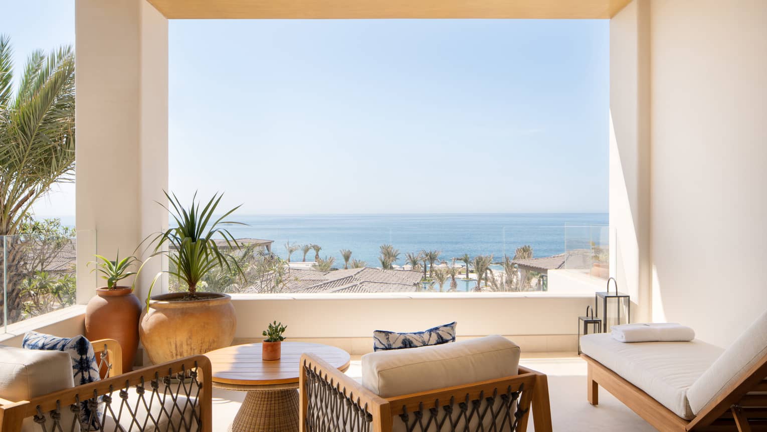 Luxury villa ocean-view covered terrace with two arm chairs and a chaise, at Four Seasons Resort Cabo San Lucas at Cabo Del Sol