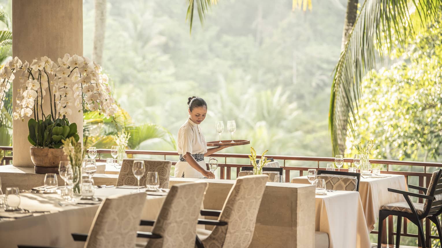 Hotel staff sets restaurant table in Ayung Terrace