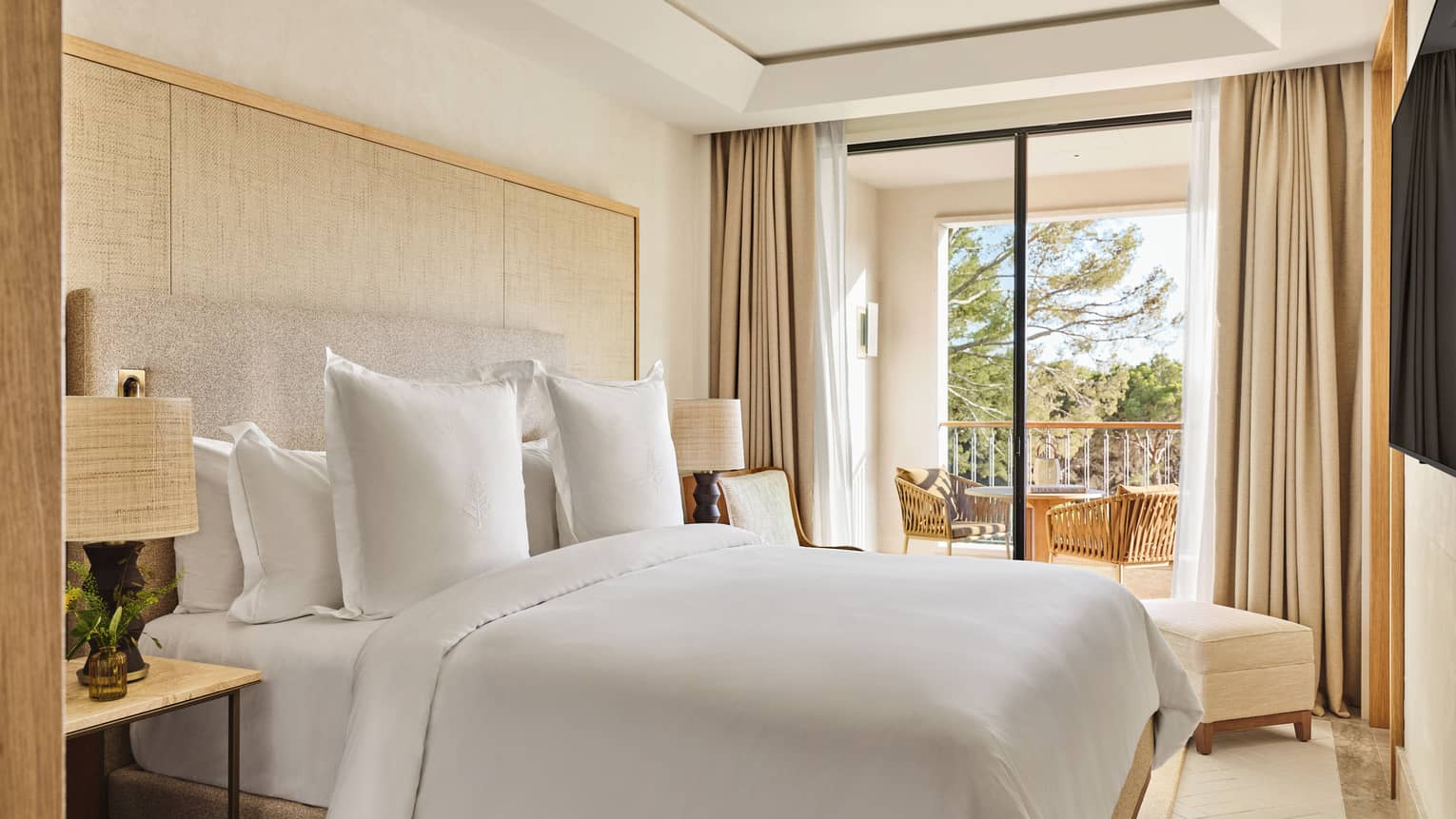 Luxury suite bedroom with king bed and walk-out balcony with garden view at Four Seasons Resort Mallorca