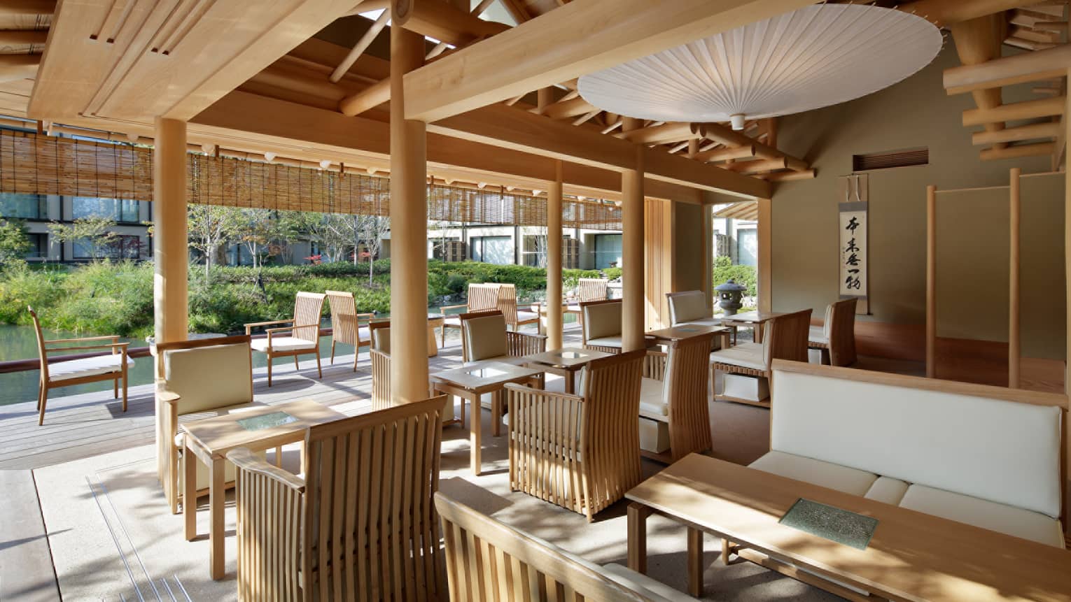 Shakusui-tei sunny patio with wood chairs, tables under white paper umbrella