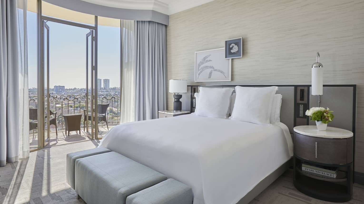 Hotel room with king bed and city-view balcony