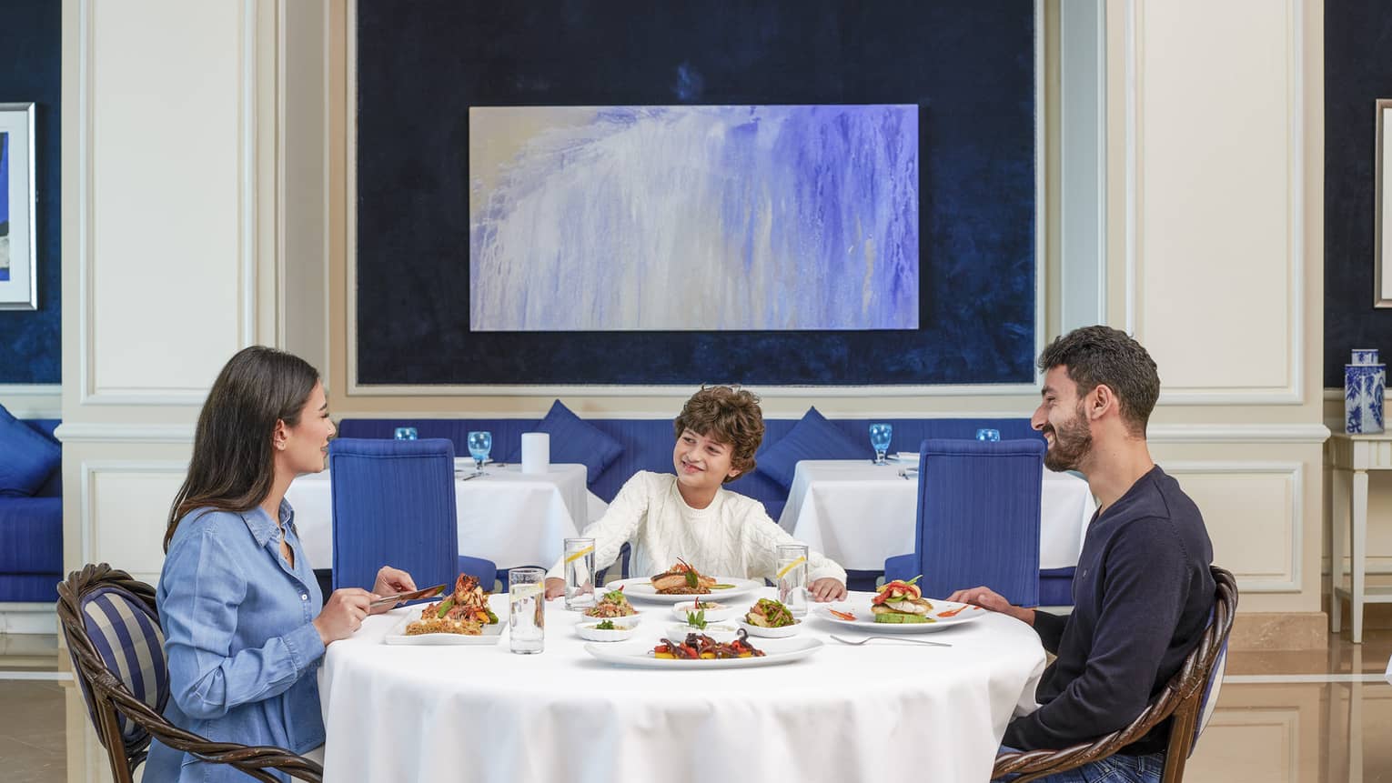 Family of three dines at Kala Restaurant, blue accents