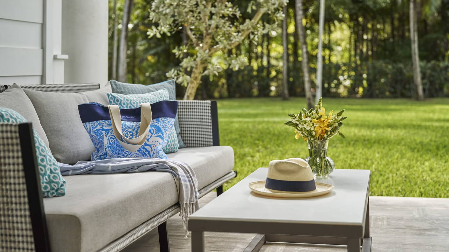 Terrace with two-seat sofa and coffee table, set against a lush green lawn