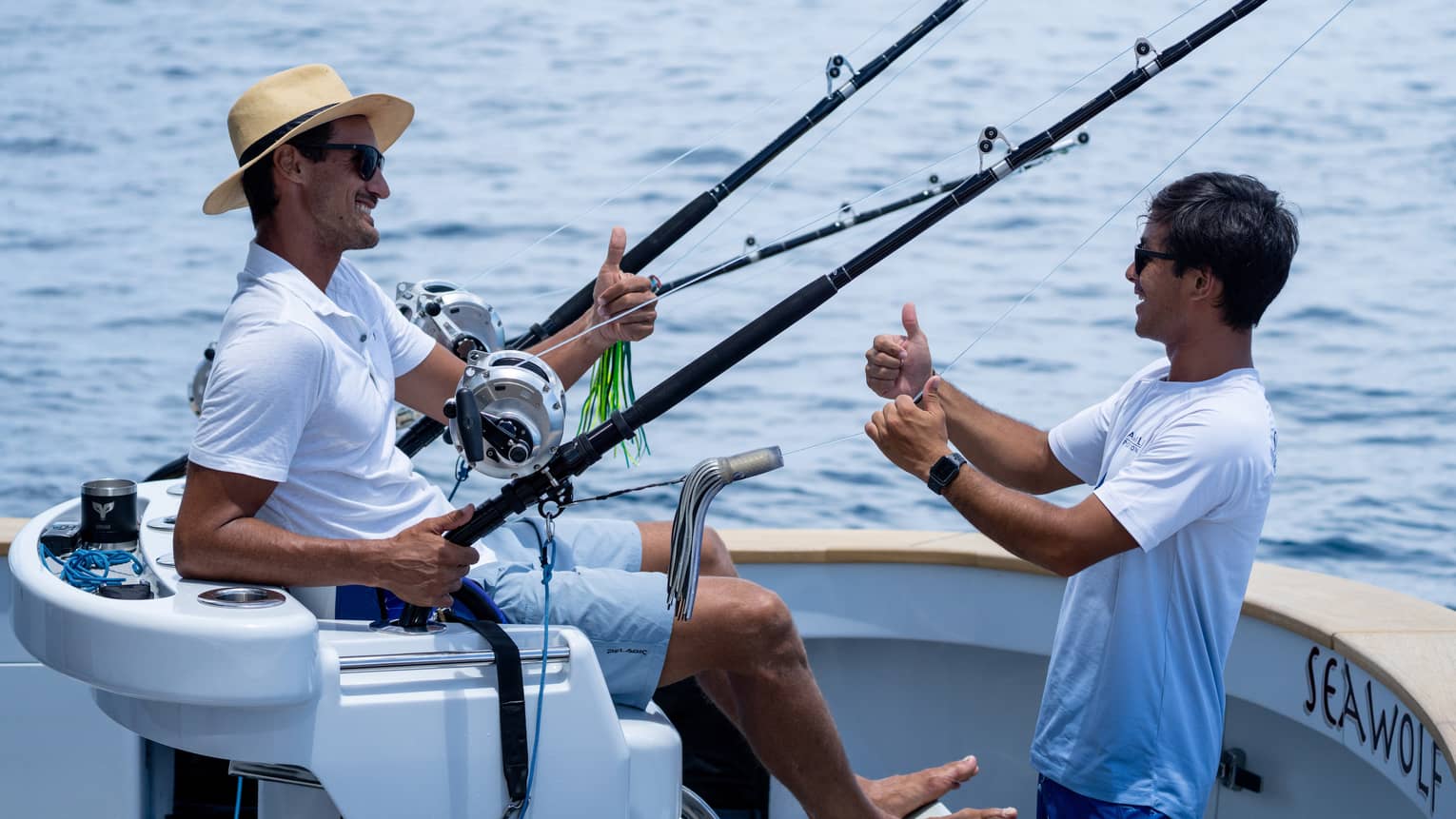 Two men talk on a fishing boat at sea