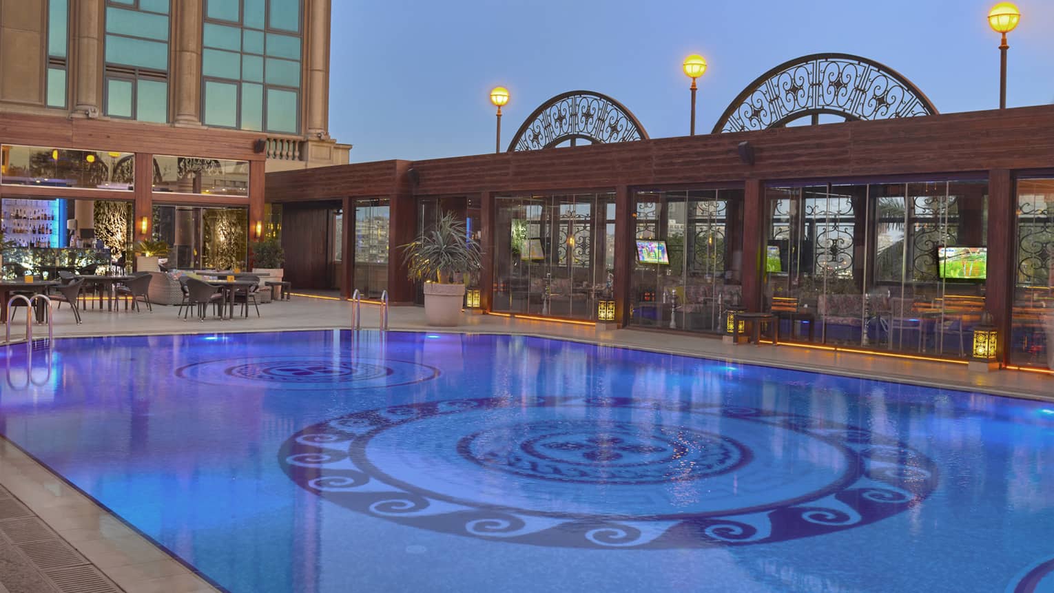 Outdoor pool illuminated under moonlit sky