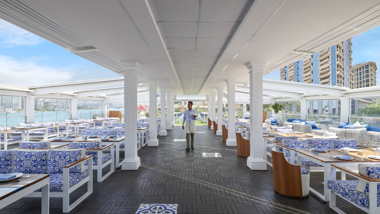 Waiter walks down the aisle of seats at open-air Zoe