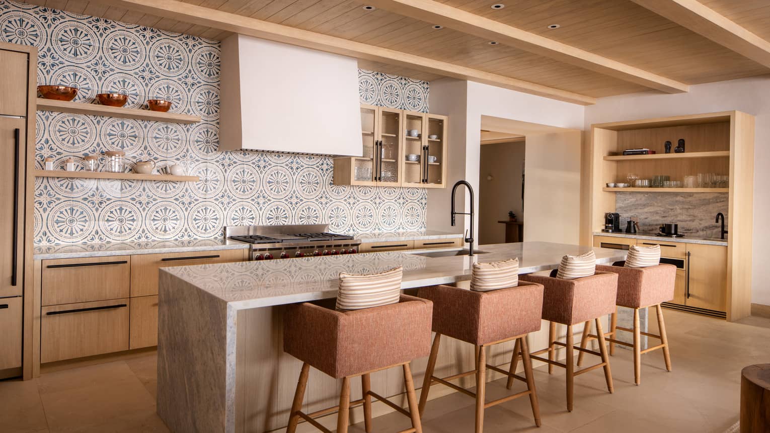 Luxury villa kitchen with mosaic tiled wall and island with four bar chairs at Four Seasons Resort Cabo San Lucas at Cabo Del Sol