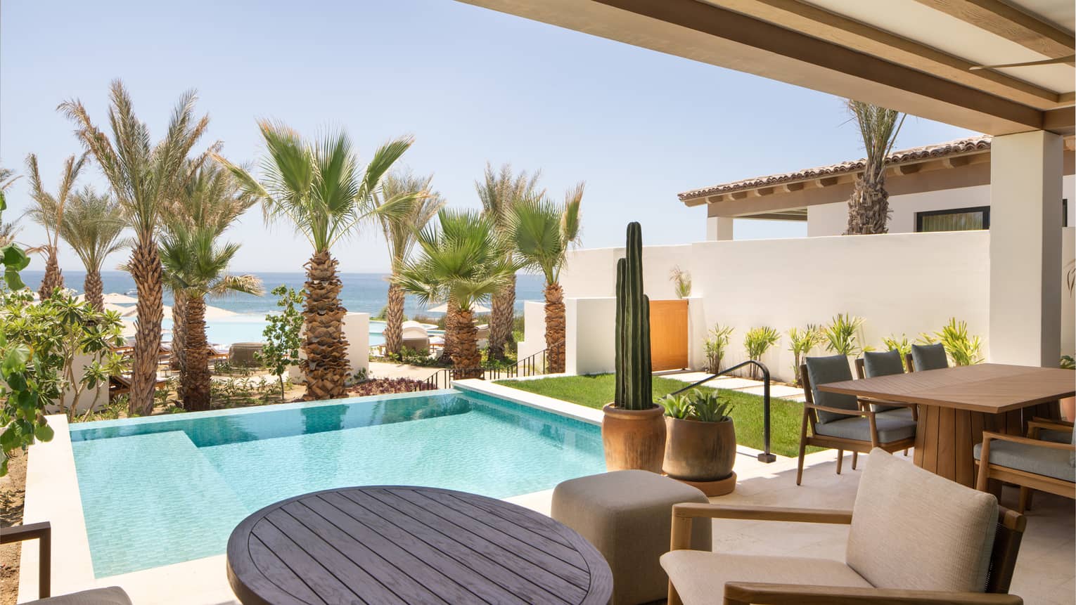 Covered terrace with private pool and view of palm trees and sea