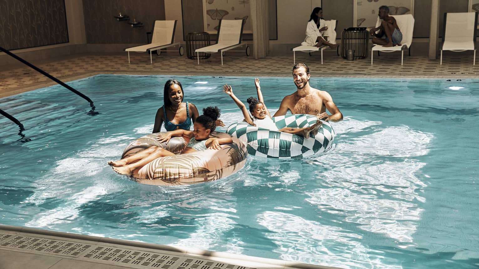 A family in a pool with round tubes.