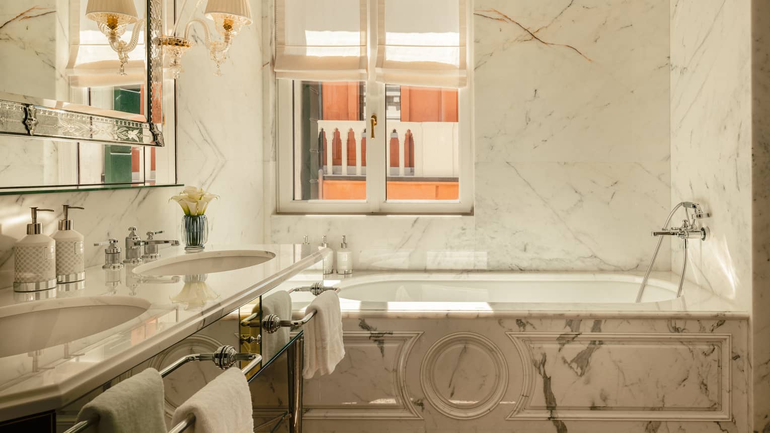 Italian marble bathroom featuring a tub next to a window