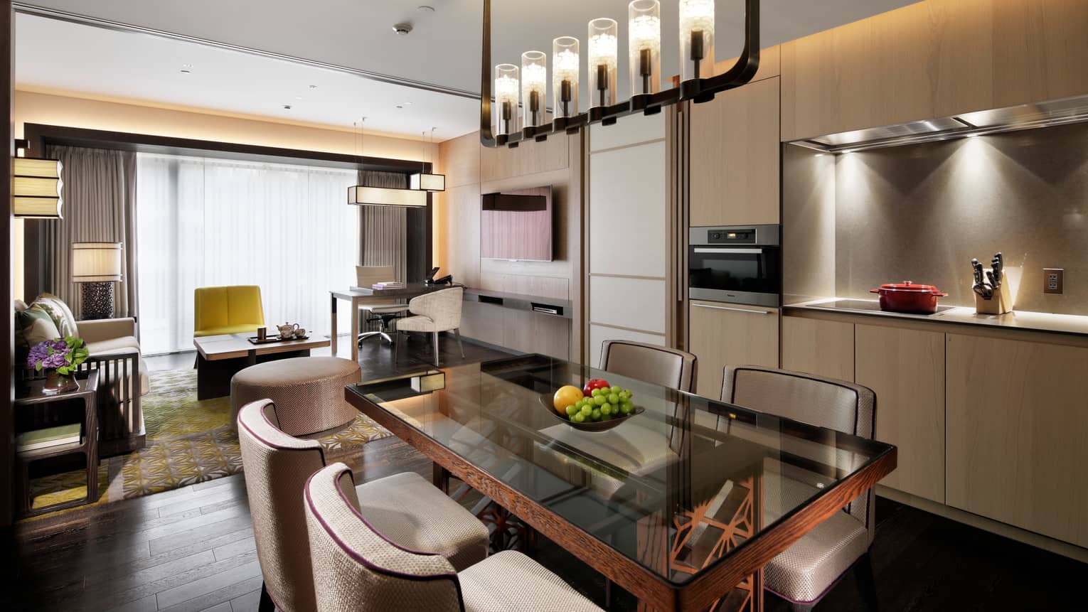 Residence dining table, fruit bowl under candle chandelier, modern kitchen, living room