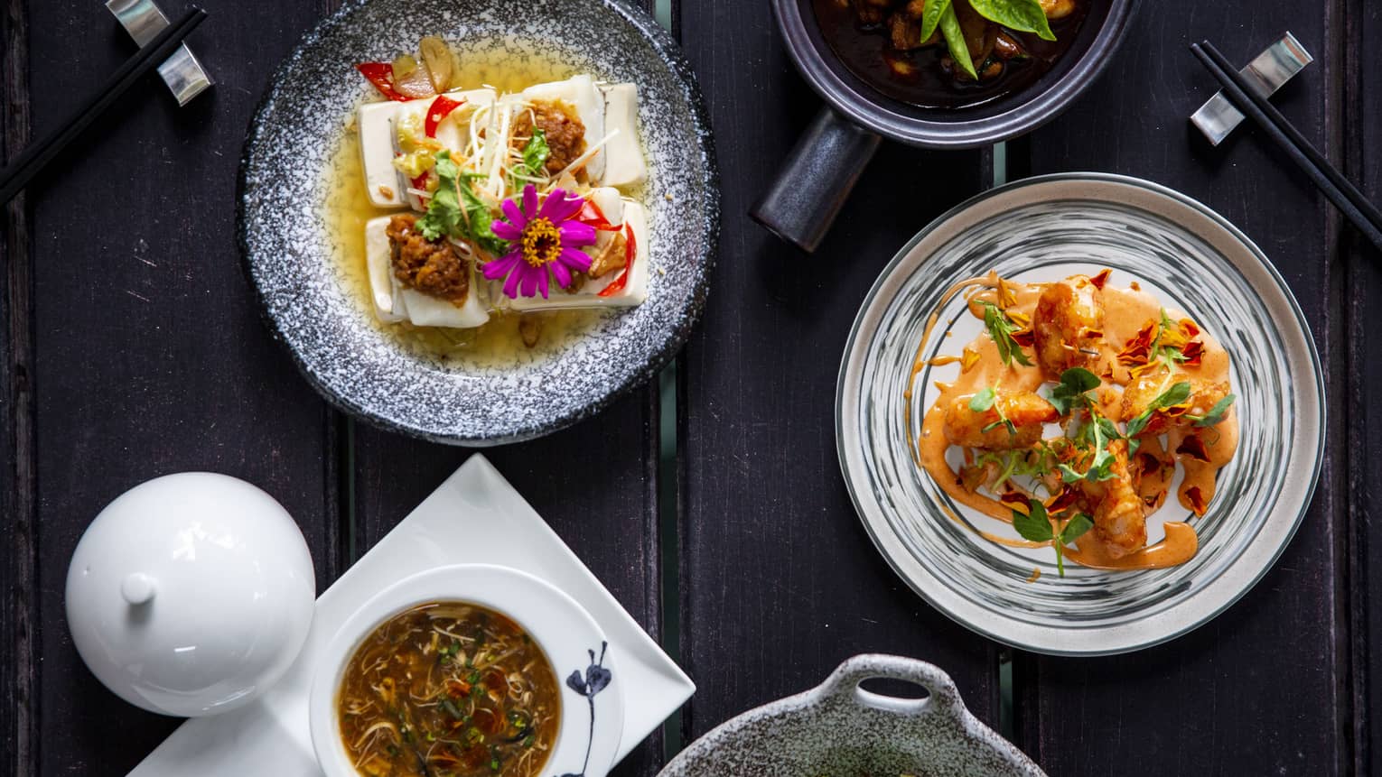 Five colourful dishes made of veggies and flowers on a dark wooden table at Cafe' Landaa