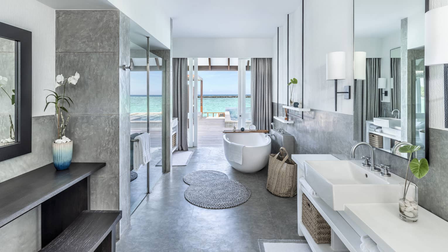 Bathroom with single vanity, large soaking tub and glass door shower, doorway to pool deck