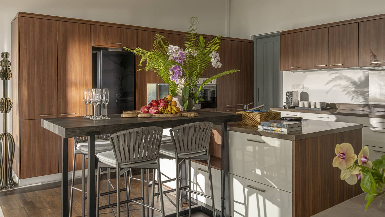 A gourmet kitchen featuring modern wooden cabinets and a high-top table with four chairs